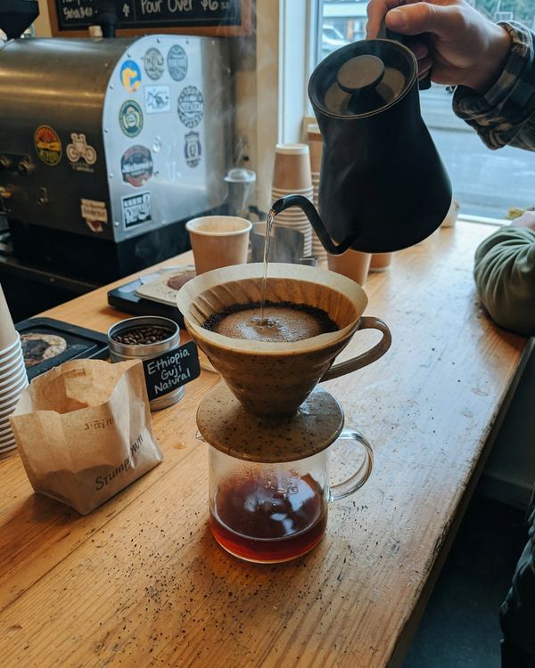 A pour-over brewing on a café counter